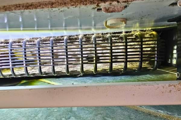 Grosse accumulation de poussière sur les serpentins du frigo non nettoyés.