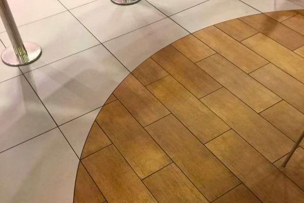 Sol composé de carrelage clair et imitation bois.