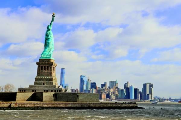 Une vue de la Statue de la Liberté avec les gratte-ciel de New York en arrière-plan.