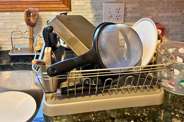 Vaisselle propre bien rangée sur un égouttoir de cuisine.