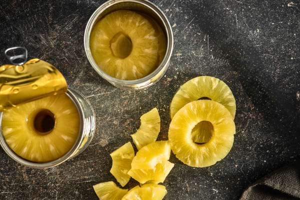 Des rondelles d’ananas en conserve sont présentées avec des morceaux découpés à côté.