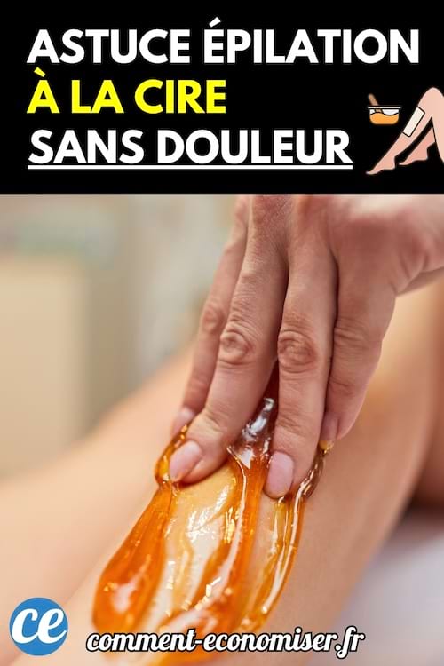 Une main applique de la cire chaude ambrée sur une jambe pour une épilation manuelle.