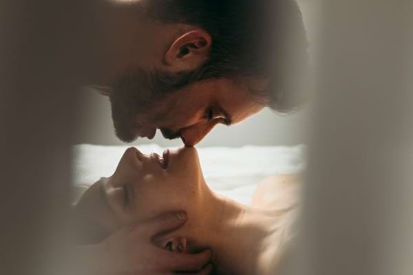 Baiser passionné entre un homme et une femme allongés.