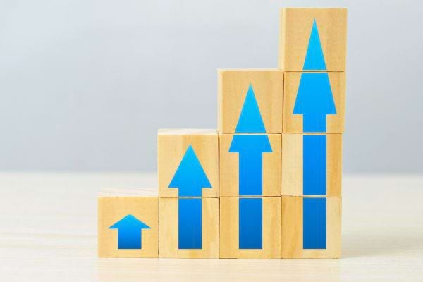 Blocs en bois empilés avec flèches bleues pointant vers le haut.