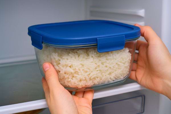 Une boîte hermétique en verre remplie de riz blanc est placée dans un réfrigérateur.