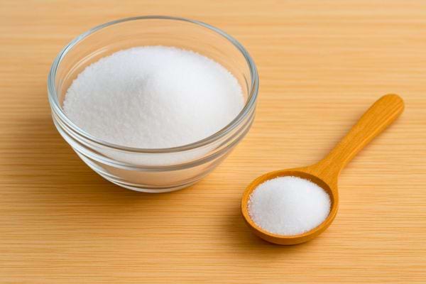 Bol de poudre blanche accompagné d’une petite cuillère en bois.