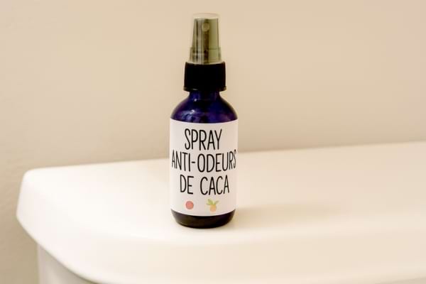 Flacon spray anti-odeurs posé sur une chasse d’eau.