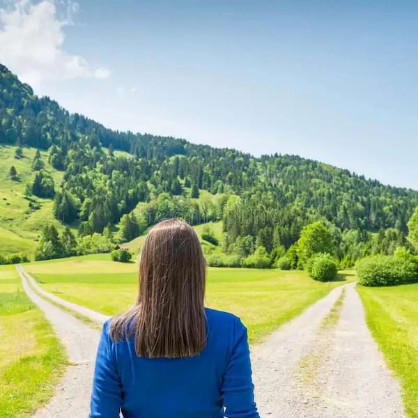 une femme en bleu devant 2 chemins possibles