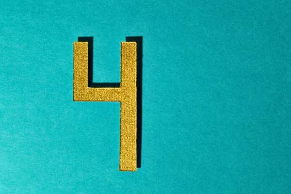 Le chiffre quatre doré est posé sur un fond bleu vif.