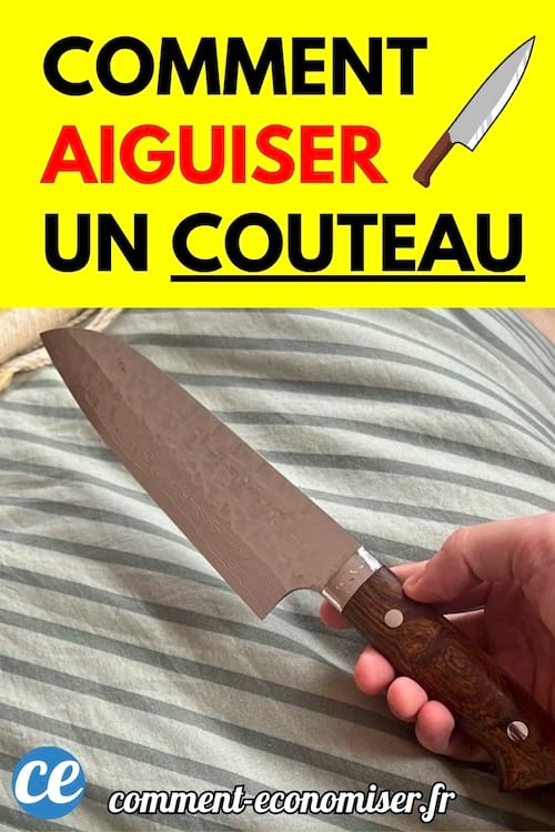Une main tient un couteau de cuisine à lame large avec un manche en bois, posé sur un tissu rayé.