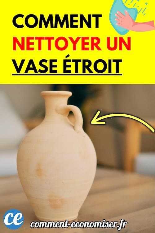 Un vase étroit en céramique beige avec une petite anse posé sur une table.