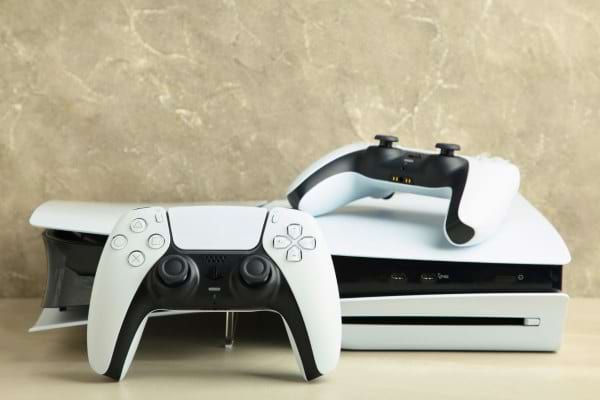 Console de jeux vidéo blanche avec deux manettes.