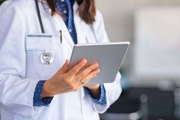 Un médecin consulte une tablette numérique pour analyser des résultats médicaux.