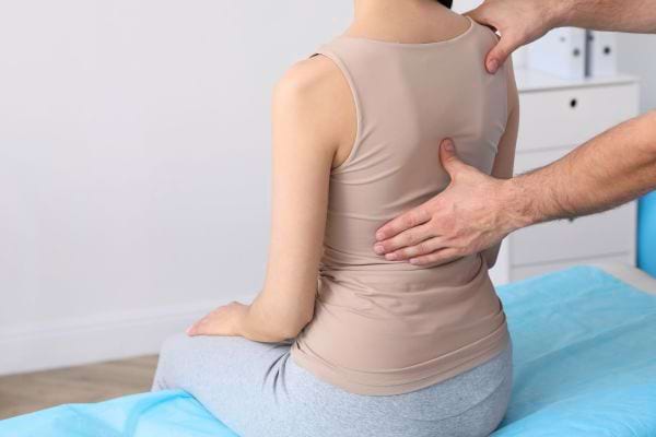 Personne examinée au dos par un praticien.