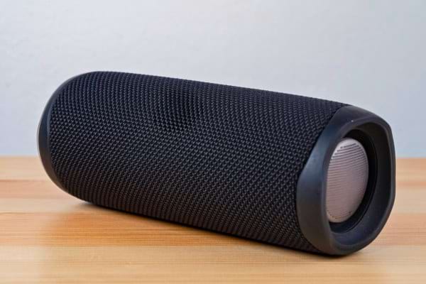 Enceinte Bluetooth noire posée sur table.