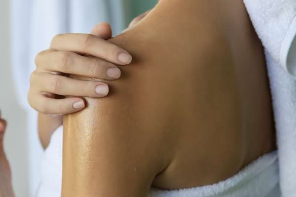 Épaule féminine avec peau hydratée.