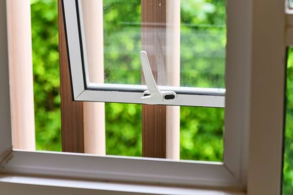 Une fenêtre entrouverte laisse entrer l’air frais dans la maison.