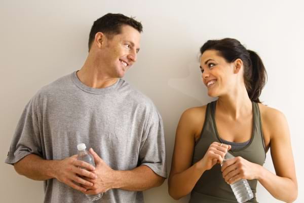 Homme et femme discutant après une séance de sport.