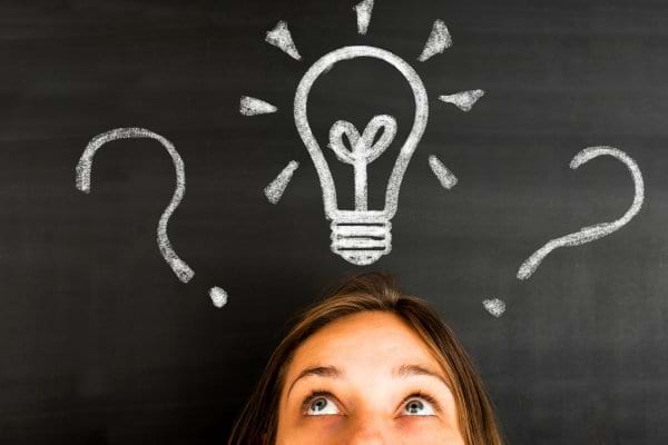 Une ampoule dessinée à la craie symbolise une idée au-dessus d’une tête.