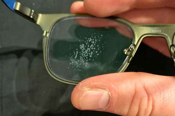 Verre de lunettes avec taches blanches.