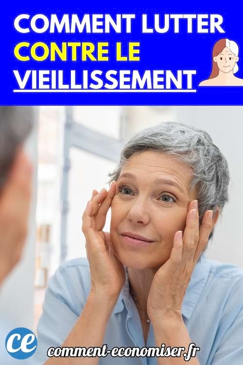 Une femme aux cheveux gris se regarde dans le miroir en touchant la peau de son visage.