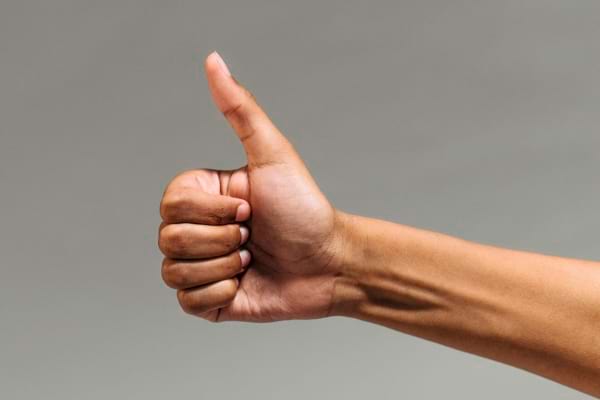 Main faisant un signe de pouce levé.