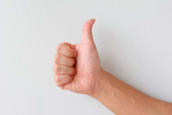 Main montrant un pouce levé.