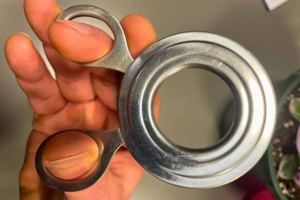 Main tenant un ustensile métallique inconnu.