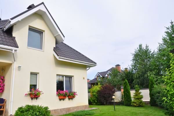 Jolie maison avec jardin fleuri et façade claire.