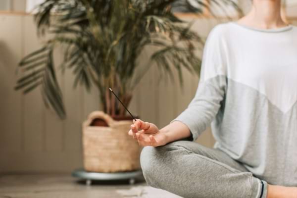 Femme assise en méditation avec encens.