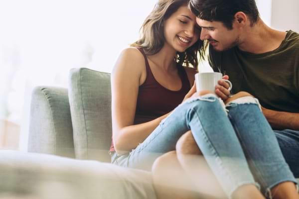 Deux amoureux se rapprochent, partagent un moment doux avec une tasse de café.  