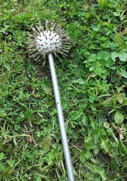 Un objet décoratif recyclé pour le jardin composé d'une tige avec une balle et des vis