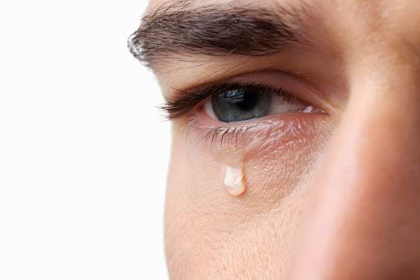 Un gros plan montre un œil avec une larme.