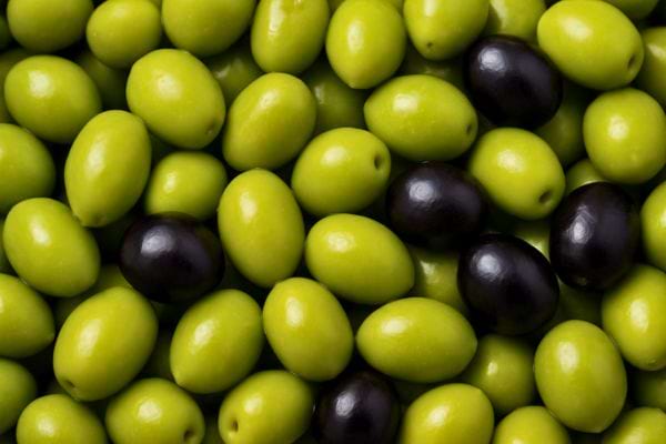 Un tas d’olives vertes avec quelques noires mélangées.