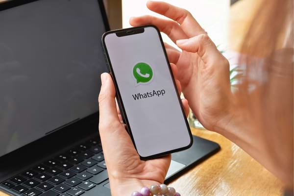 Femme ouvrant l’application WhatsApp sur son smartphone.