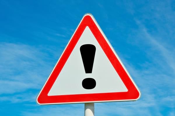 Panneau de signalisation triangulaire avec point d’exclamation noir.