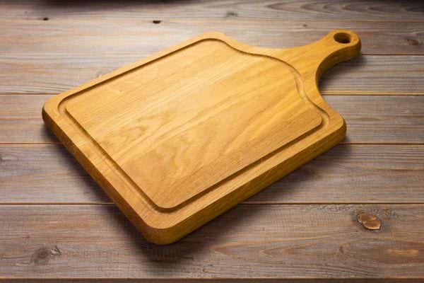 Une planche à découper en bois posée sur une table.