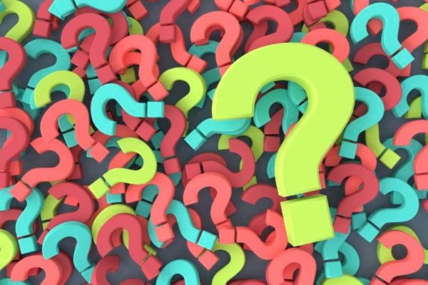 De nombreux points d’interrogation colorés (verts, rouges, bleus) superposés sur un fond gris.