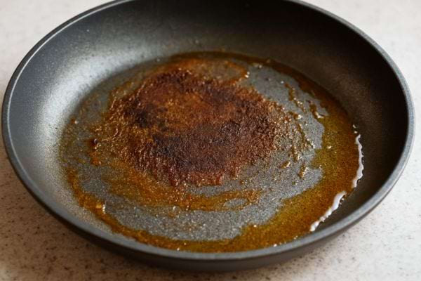 Poêle avec une épaisse couche de graisse brûlée au centre.