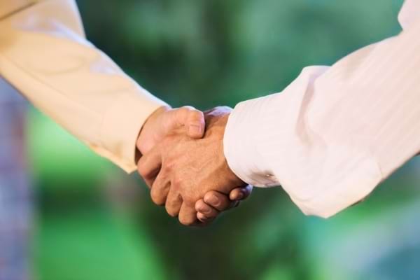 Deux personnes se serrent la main, symbole d’un accord ou d’un engagement.