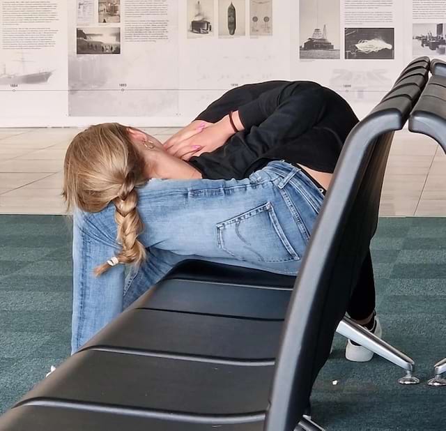 Personne allongée sur un siège donnant une posture inhabituelle.