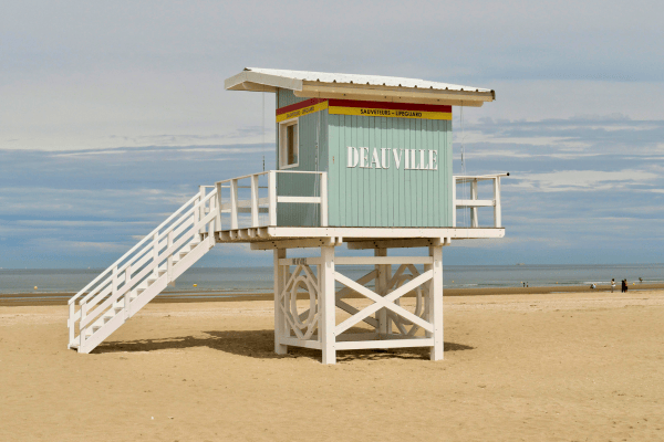 Un poste de secours sur la plage de Deauville, vide, sous un ciel nuageux.