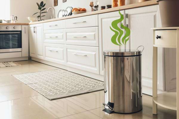 Poubelle métallique de cuisine dégageant des mauvaises odeurs vertes.