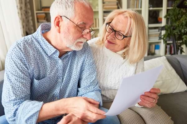 Couple de seniors lisant ensemble un document important.