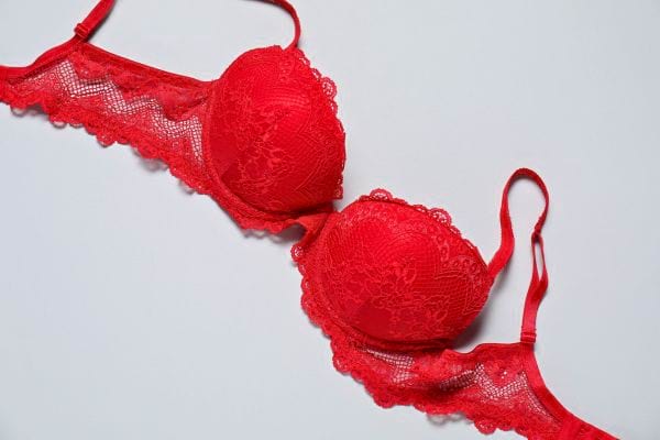 Soutien-gorge rouge en dentelle posé à plat.