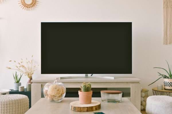 Télévision éteinte posée sur un meuble dans un salon décoré.