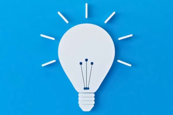 Illustration d’une ampoule blanche allumée sur fond bleu.