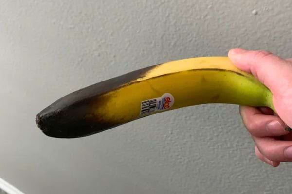 Une banane à moitié noire montrant les effets du mauvais stockage.