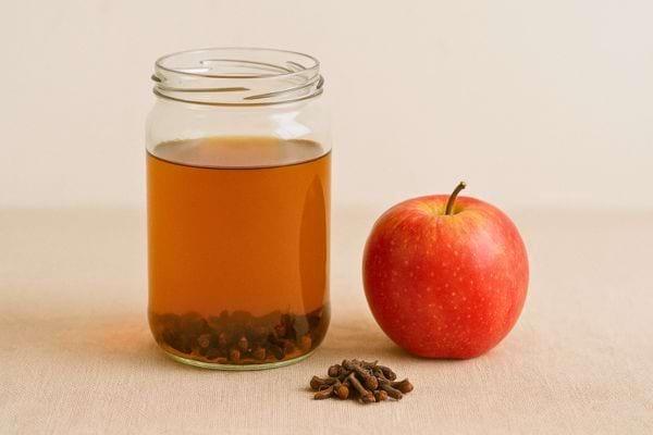 Bocal de vinaigre avec clous de girofle au fond.