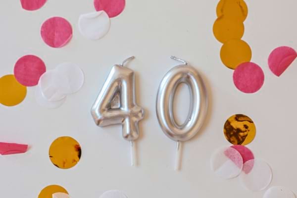Deux bougies argentées en forme du nombre 40 posées avec des confettis.